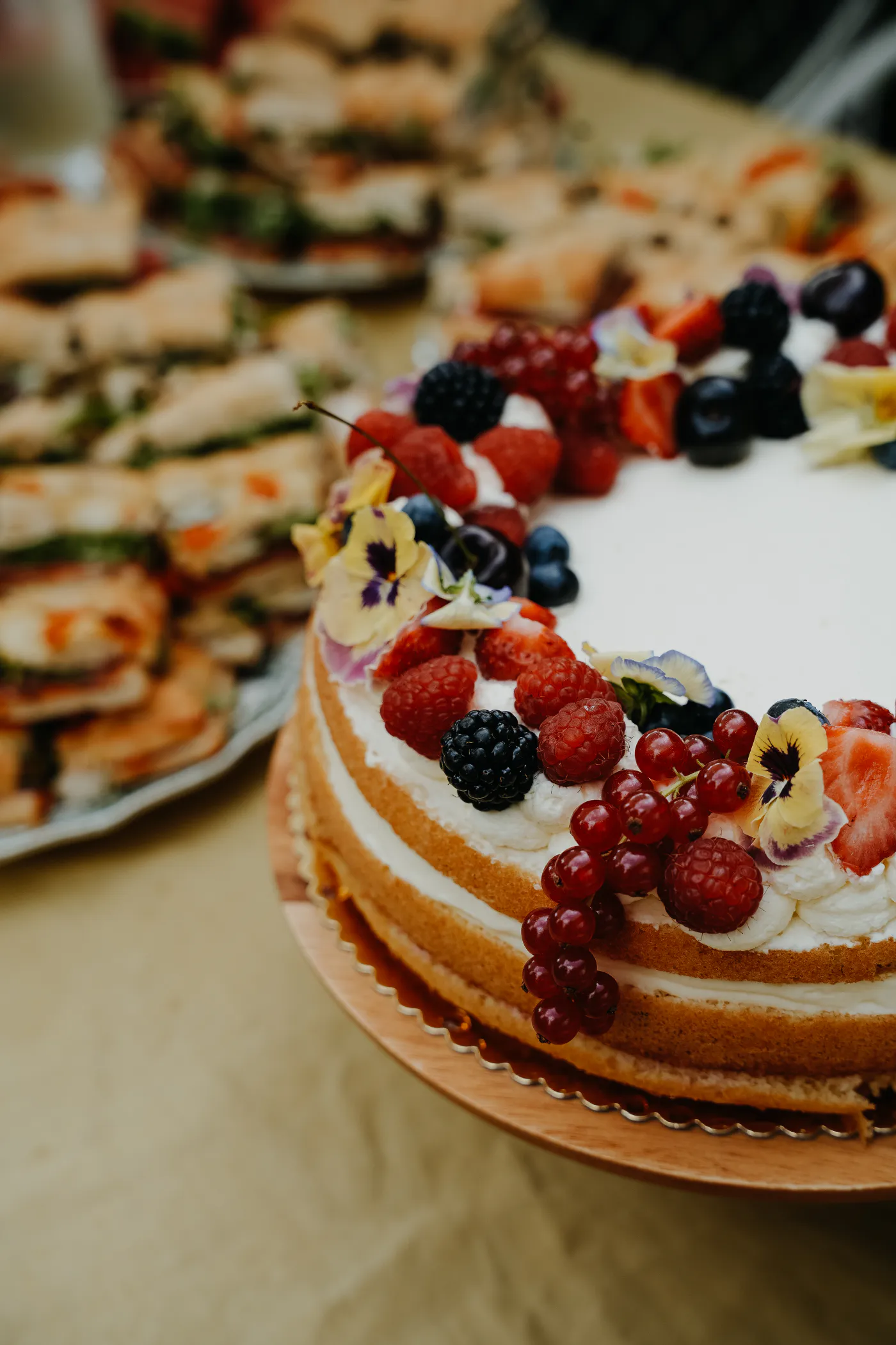 Feestelijke taart met rood fruit en eetbare bloemen